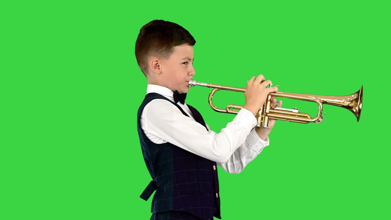 Giovane ragazzo con un papillon che suona la tromba ondeggiando da un lato all'altro su Green Screen, Chroma Key