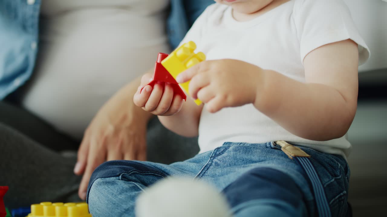 video de una madre jugando con bloques de juguete con su hijo.