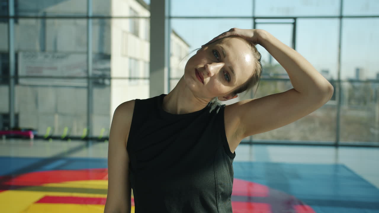 mujer estirándose en un gimnasio