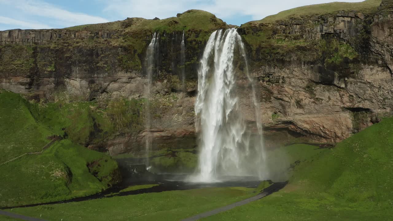 volando lejos de la cascada de seljalandsfoss revelando las tierras altas de islandia