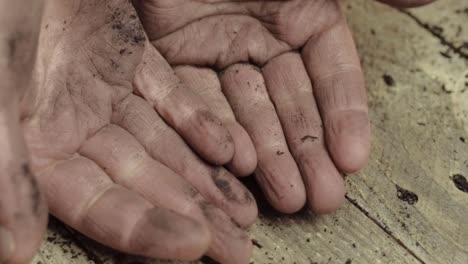 Par-De-Manos-Sucias-Abiertas-Contra-El-Fondo-De-Madera