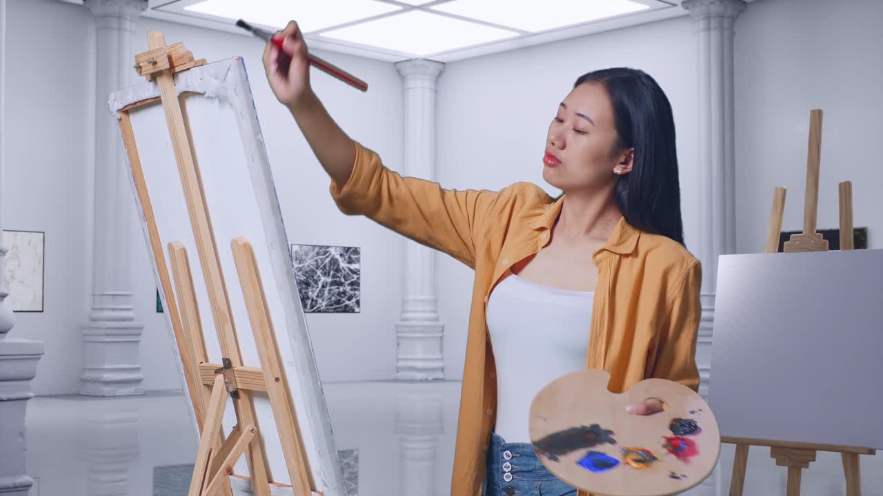 갤러리에서 오일 페인트와 으로 캔버스에 그림을 그리는 아시아 여성 예술가