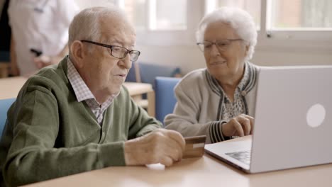 senior people trying to shop online with laptop in geriatric