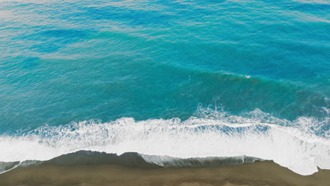 ocean in a strong storm with long waves crashing on the sandy beach