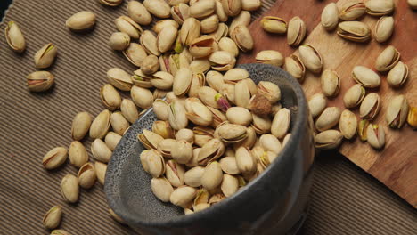 close up overhead shot looking down into bowl containing pistachio nuts revolving