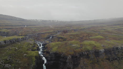 Luftwagen-über-Fluss,-Wasserfall-In-Richtung-Straße-Durch-Bergsteppen-Von-Island