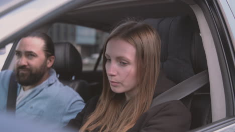 pareja discutiendo acaloradamente dentro de un auto mientras ella conduce