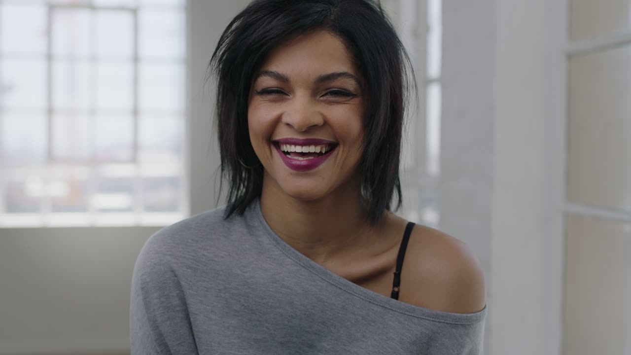 retrato de una joven independiente de raza mixta riendo alegremente mirando a la cámara disfrutando de la diversión