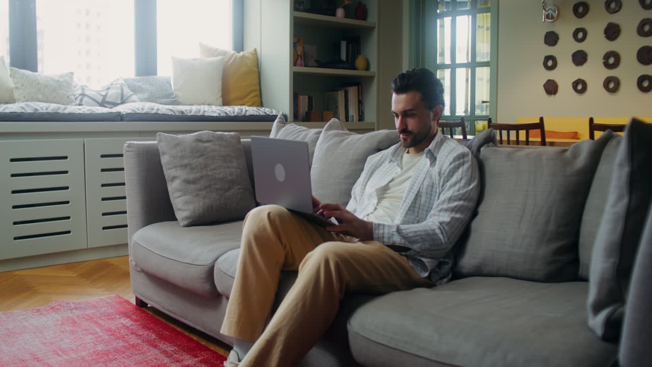 Man Working on Laptop in Living Room