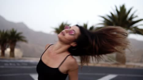 super positiva, emocionada joven mujer con estilo en pantalones blancos posando, bailando en la carretera