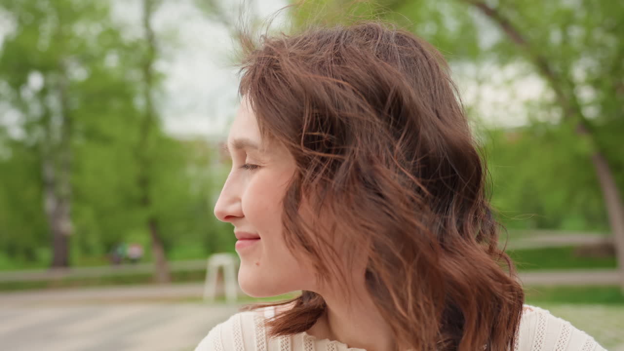 Woman With Joyful Facial Expression, Caucasian Lady Showcasing Cheerful Smile In Park Setting, Female With Curly Hair Posing Confidently Amidst Peaceful Green Scenery Using Gentle Sunlight