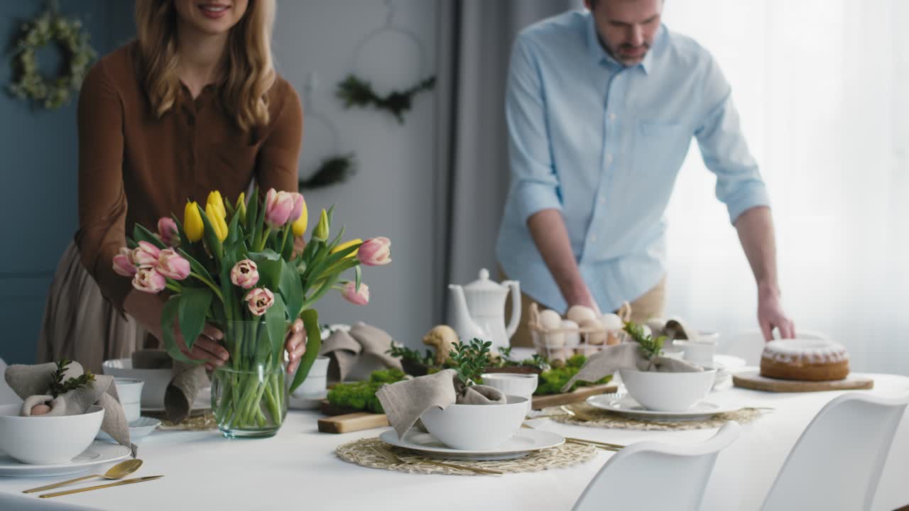 Caucasian couple preparing  table for easter dinner.