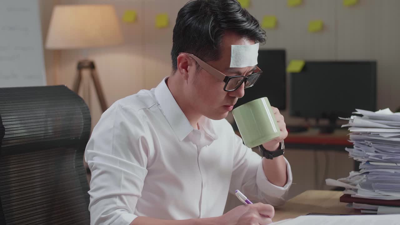사무실에서 문서와 함께 열심히 일하면서 물을 마시는 아픈 아시아 남자의 근접