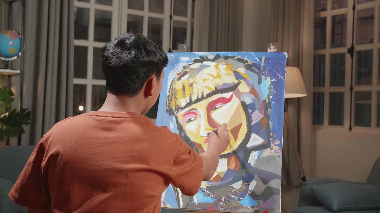 Medium Shot Hind View Of An Asian Artist Boy Holding Paintbrush Mixed Colour And Painting A Girl'S Hair On The Canvas