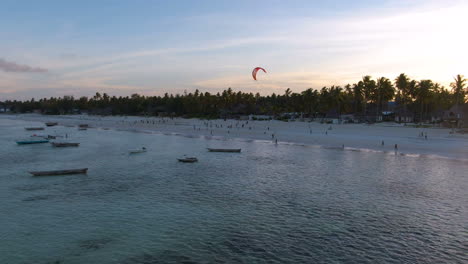 amazing sunset drone shot with a lot of fishing boats and people on zanzibar island coastline