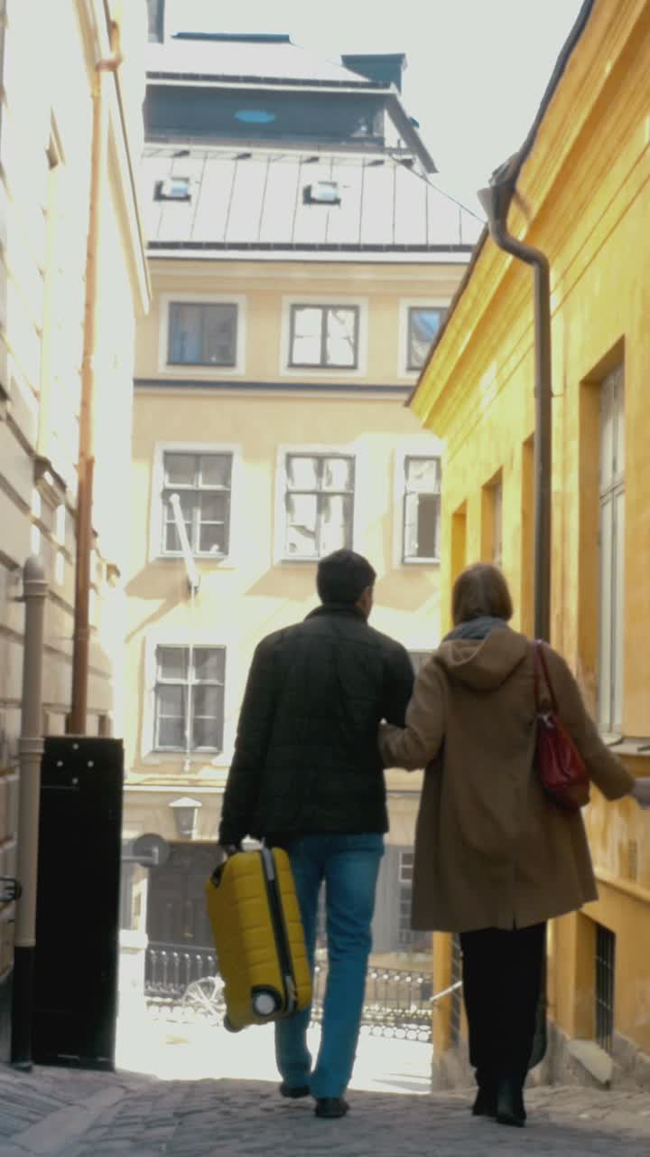 Couple Traveling Through City Streets with Luggage