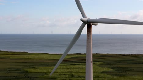 wind turbine and offshore wind farm against a coastal landscape