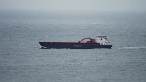 a barge in the sea in rough weather. slow-motion, pan follow.