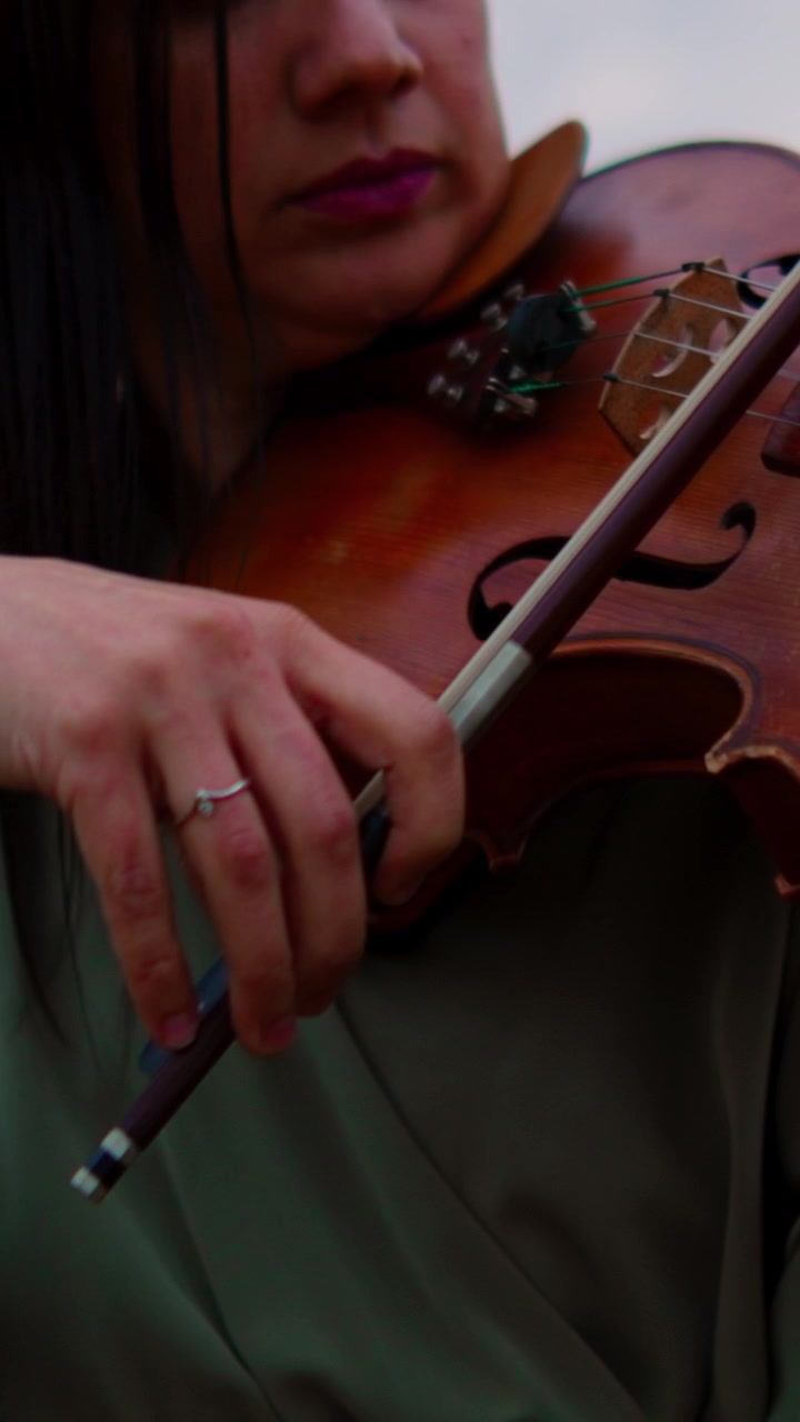 Woman Playing Violin in a Field at Sunset