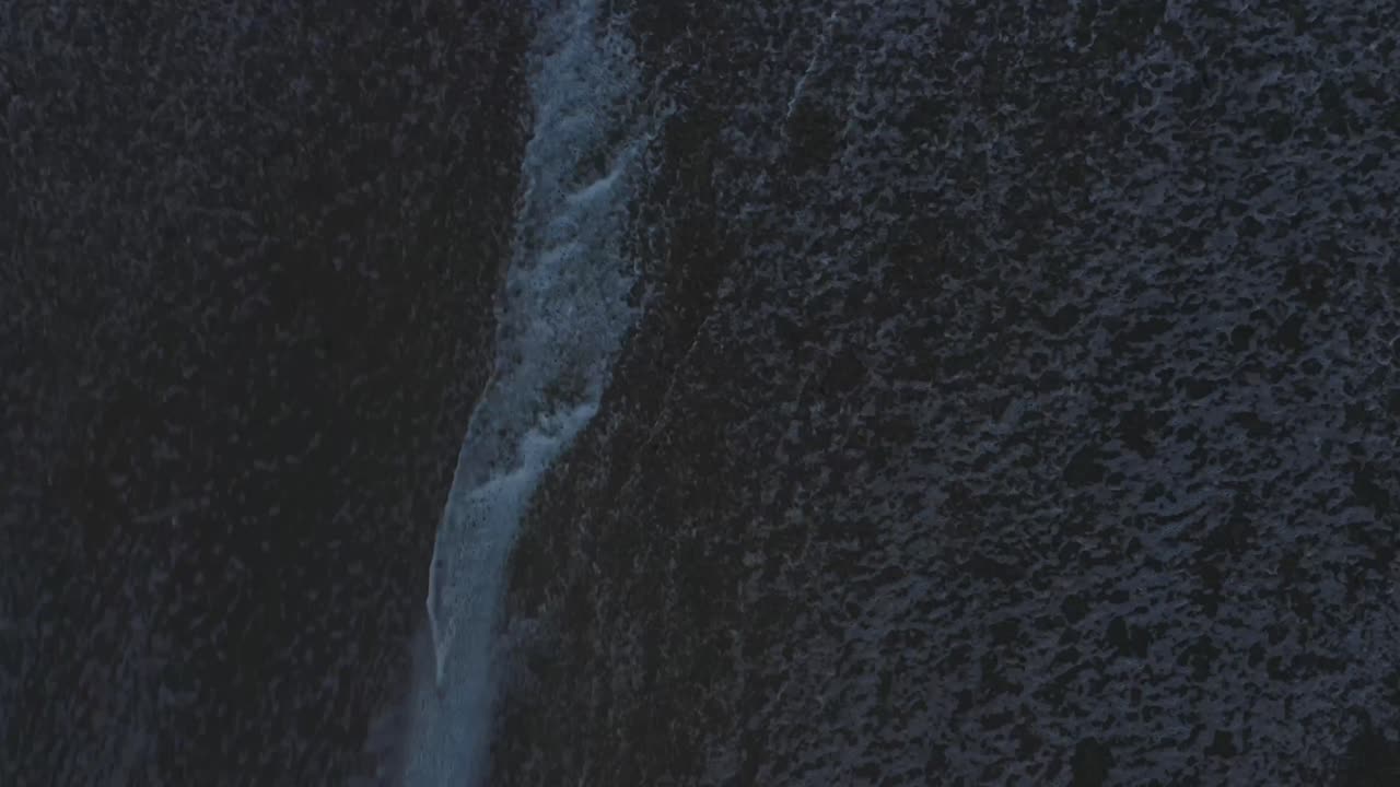 Aerial View Of Waves Crashing And Foaming On A Beach