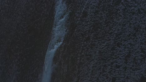 Aerial-View-Of-Waves-Crashing-And-Foaming-On-A-Beach