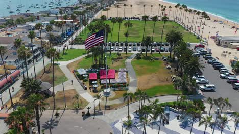 pull away aerial view of an american flag at peninsula park, in newport beach, california