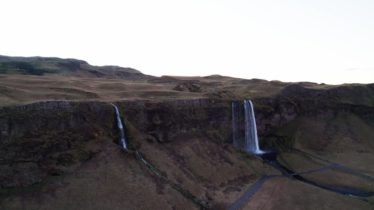 la cascada mística de seljalandsfoss en el panorama de las montañas volcánicas, aérea