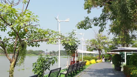 wind turbines spinning over a serene riverside park