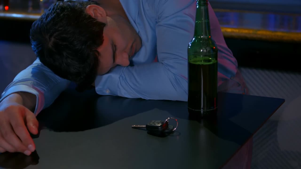 hombre borracho durmiendo con la cabeza en el mostrador