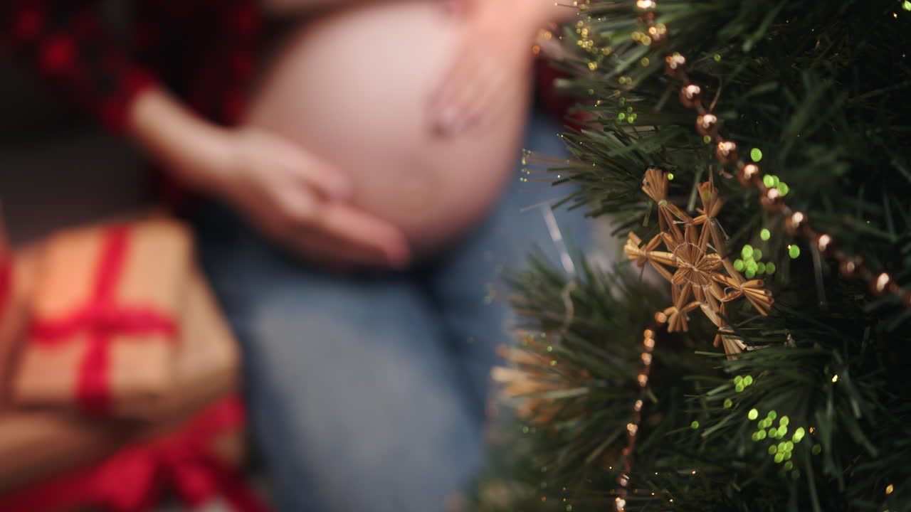 Mulher grávida decorando a árvore de Natal