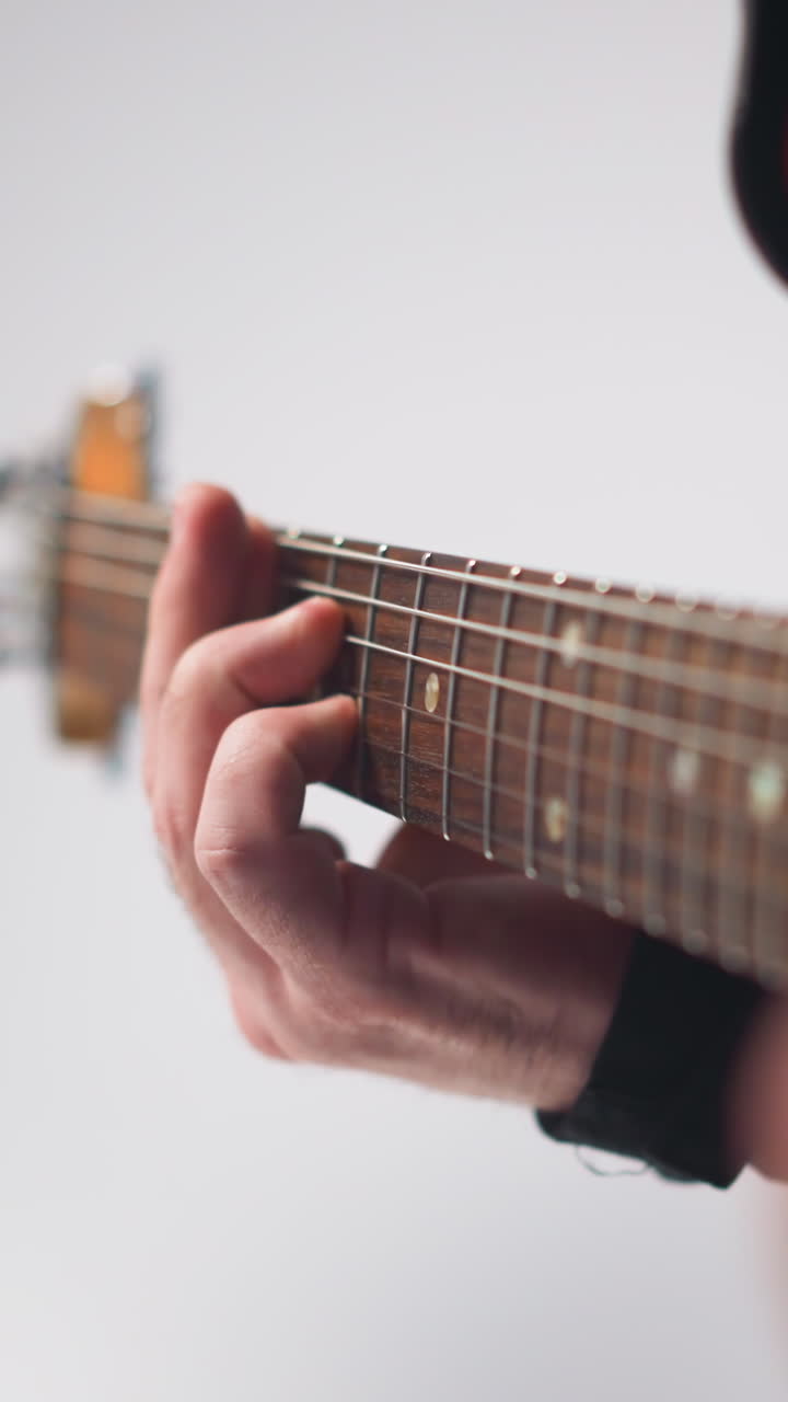 intenso primer plano de una vocalista femenina sin rostro en una chaqueta de cuero negra gestando con las manos, la cámara haciendo zoom, fondo gris