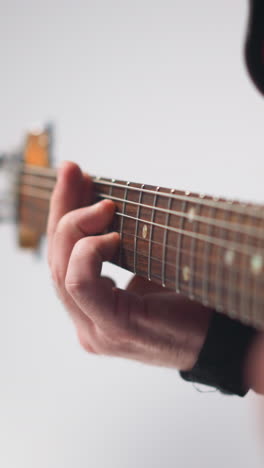 intenso primer plano de una vocalista femenina sin rostro en una chaqueta de cuero negra gestando con las manos, la cámara haciendo zoom, fondo gris