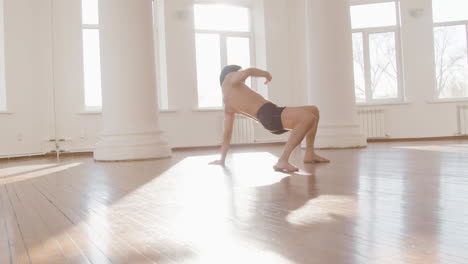 bailarín japonés masculino contemporáneo entrenando movimientos de baile en el piso del estudio 2