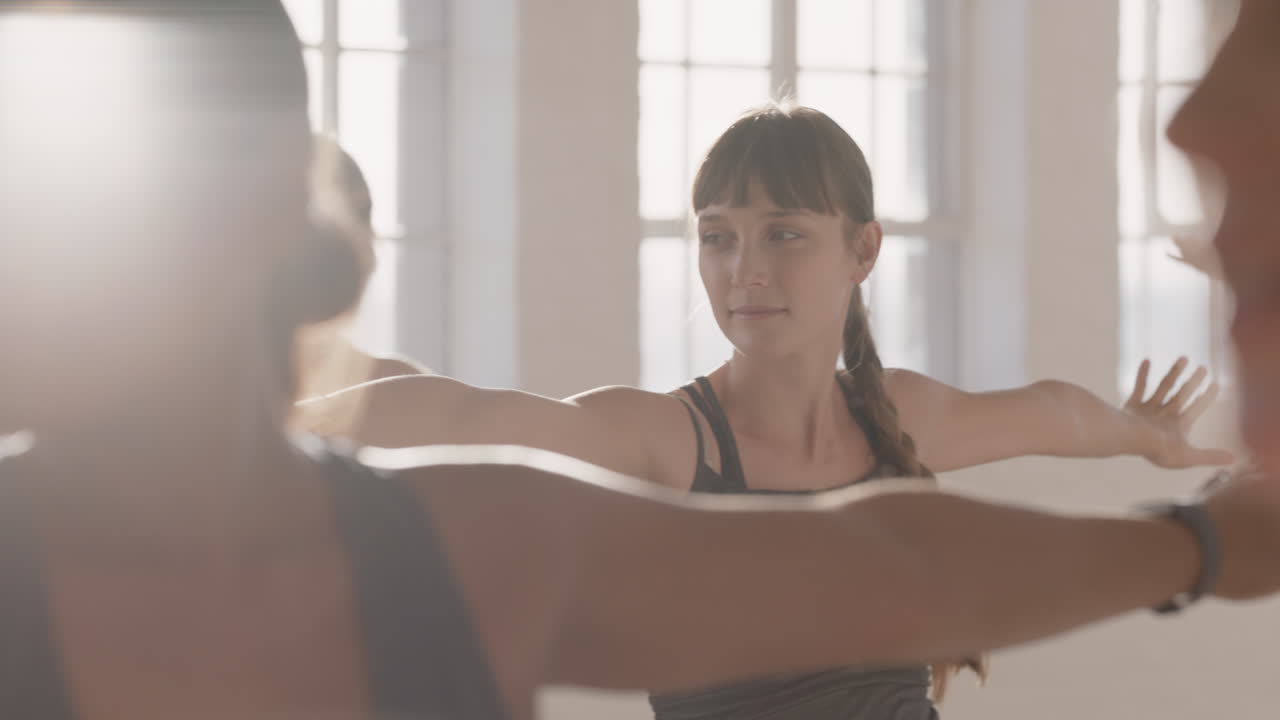 joven mujer caucásica embarazada en clase de yoga practicando pose guerrera disfrutando de un estilo de vida saludable en grupo haciendo ejercicio en el gimnasio al amanecer.