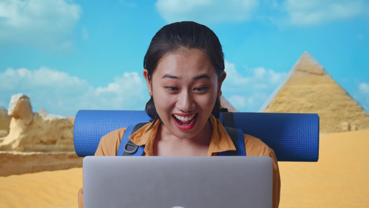 Close Up Of Asian Female Hiker With Mountaineering Backpack Looking At A Laptop And Saying Wow While Traveling In Pyramid Of Giza