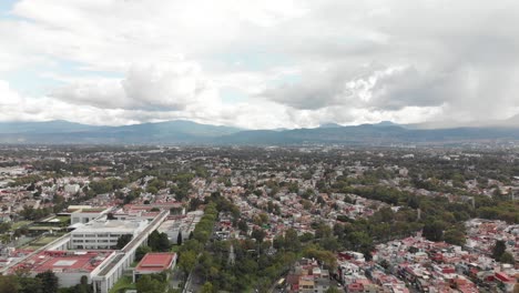 Drone-view-of-a-cloudy-day,-with-blue-sky,-over-a-residential-area-in-Mexico-City,-CDMX