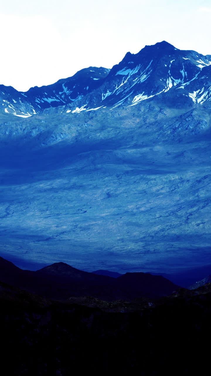 Majestic mountains rise under a bright sky with shining peaks