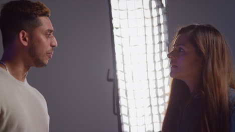 man and woman talking in a studio setting.