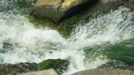 close up of a clear stream moving quickly between two rocks in slow motion