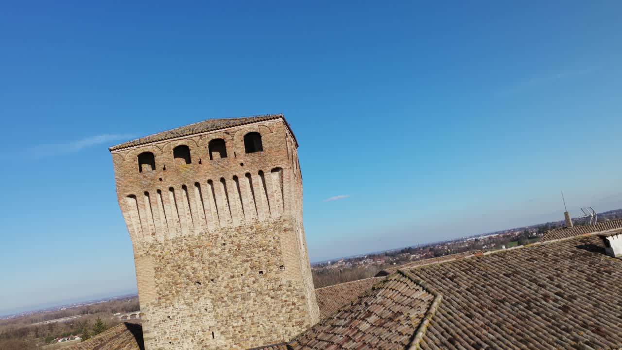 Storico Castello di Montechiarugolo contro un cielo blu soleggiato in Emilia-Romagna, Italia. Ripresa ascendente con drone FPV.