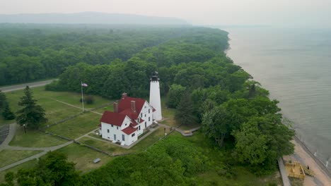 aerial view of point iriquoise lighthouse and shoreline, lake superior, michigan during canadian wildfire smoke