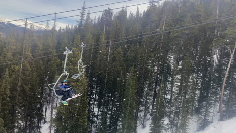 Video-footage-of-four-people-riding-a-chair-lift-up-the-mountain-in-Keystone,-Colorado
