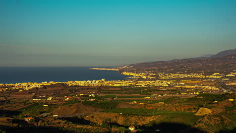 Time-lapse-of-coastal-city-transitioning,-showcasing-city-lights-flickering-to-life