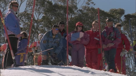 a group of people watch as a contestant begins to ski