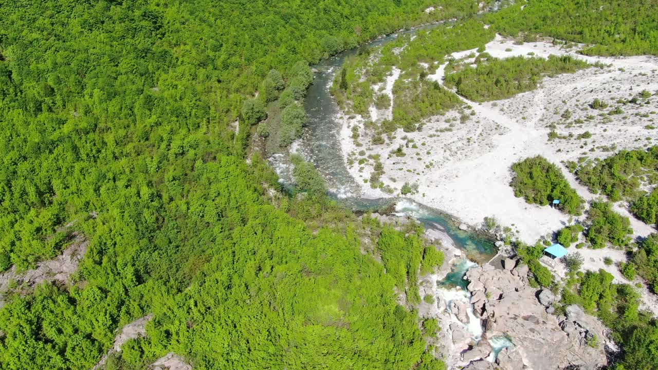 アルバニアのアルプス山脈、テスの緑豊かな谷と青い川の上を飛行するドローンからの眺め。