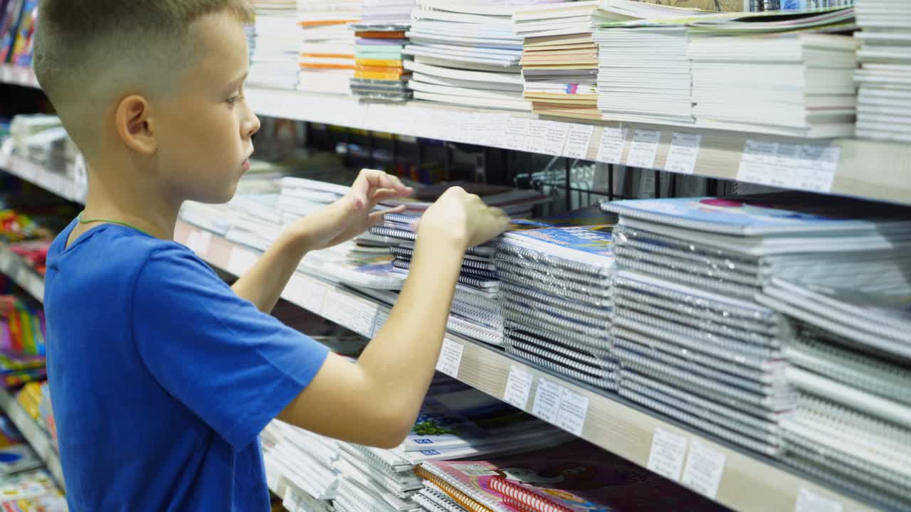 Vinnitsa, Ukraine - August, 2018: Boy chooses office supplies. Many colorful tools and supplies on the shelf of a stationery shop