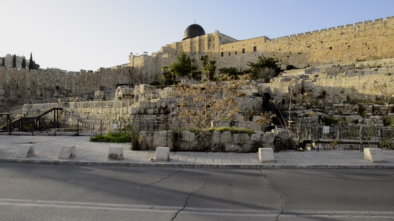Jerusalem old city fortress wall with cars passing by. Temple Mount Al-Agsa Mosque. Islamic religious building. Israel