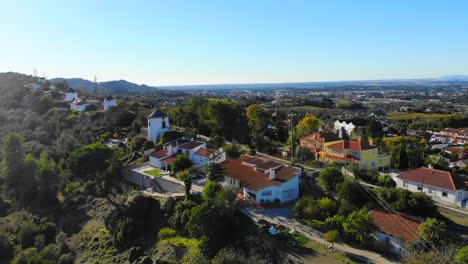 Drohnenaufnahme-Einiger-Häuser-Und-Windmühlen-Auf-Dem-Bergrücken-In-Palmela,-Portugal