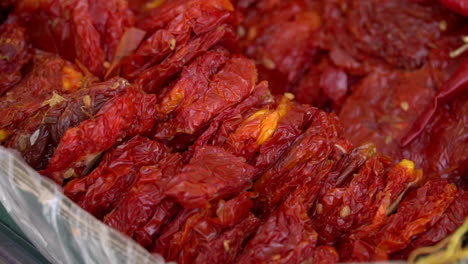 검은 바구니에 햇볕에 말린 빨간 토마토 반쪽 더미