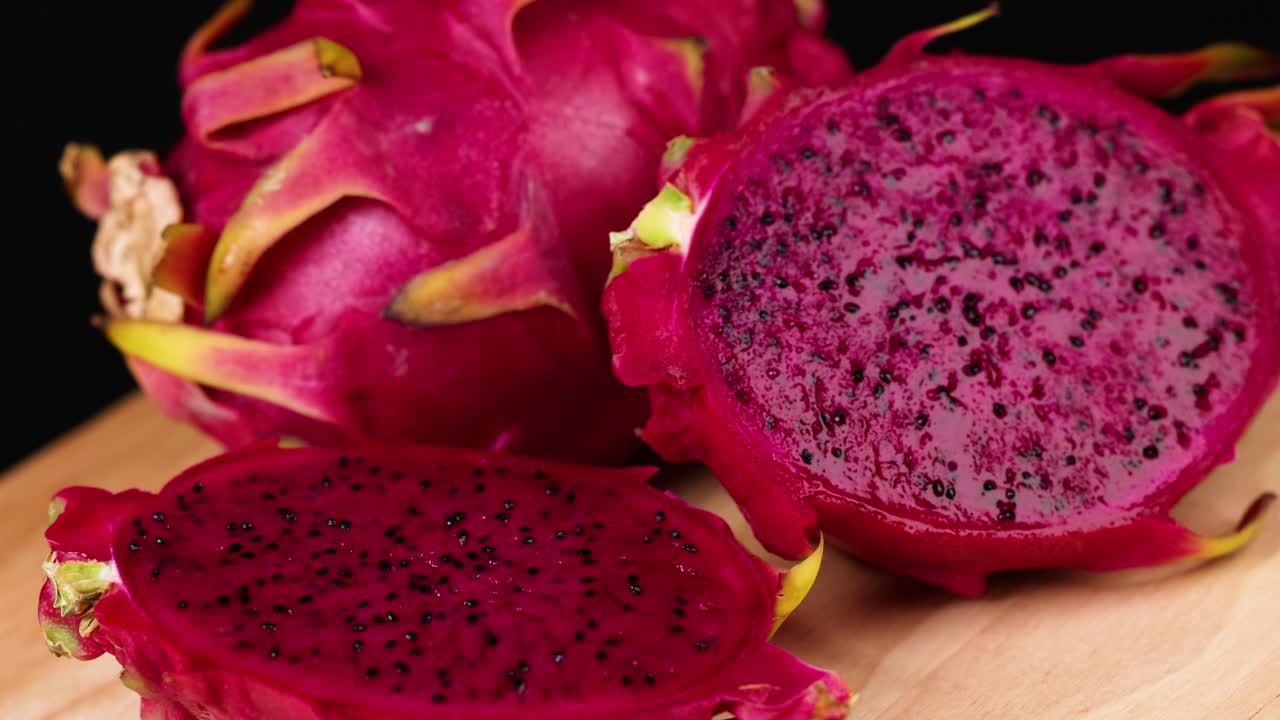 frutas de dragón en rodajas expuestas en una tabla de madera
